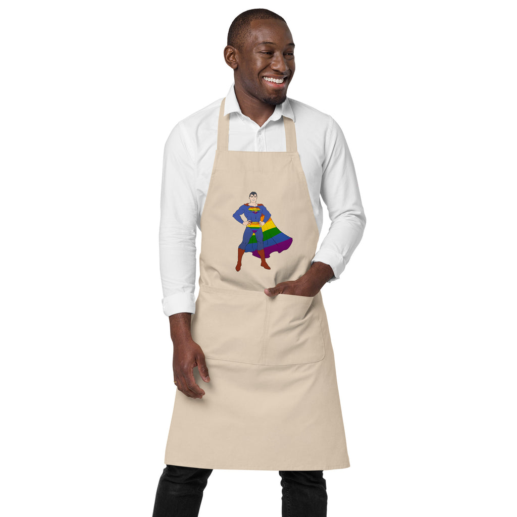 Model wearing a beige apron with a rainbow-caped superhero graphic and front pocket