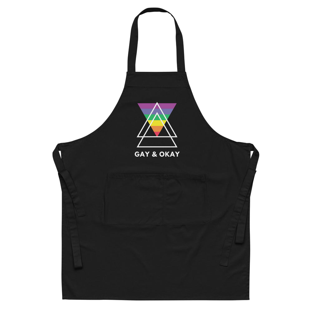 Front-view black apron with rainbow triangle graphic, “GAY & OKAY” text, and front pocket