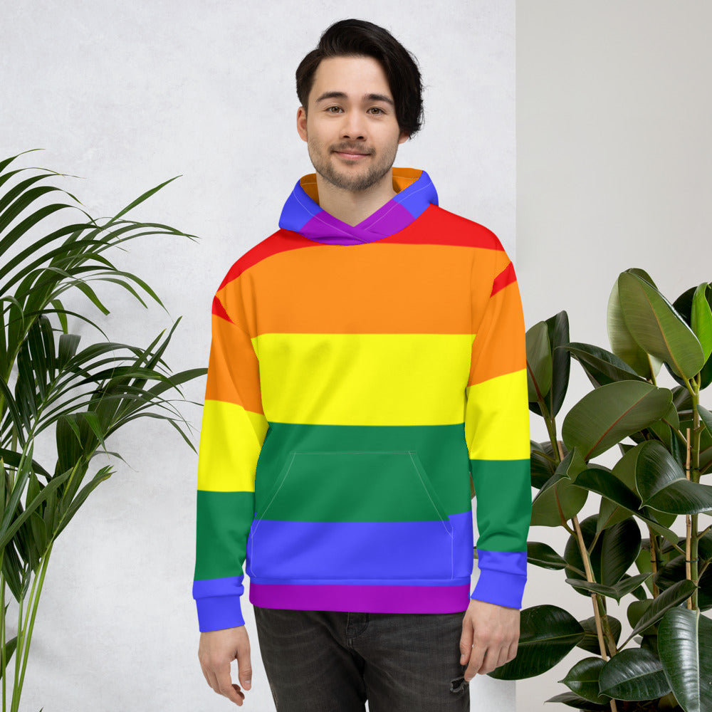 Front-facing model wearing a rainbow-striped Pride hoodie with a purple hood and kangaroo pocket