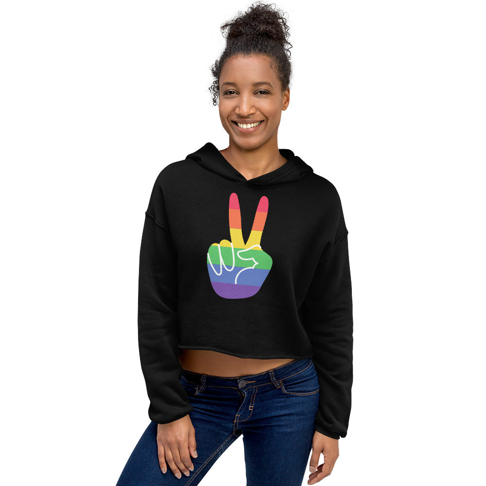 Model wearing a black cropped hoodie with a rainbow peace-sign hand graphic