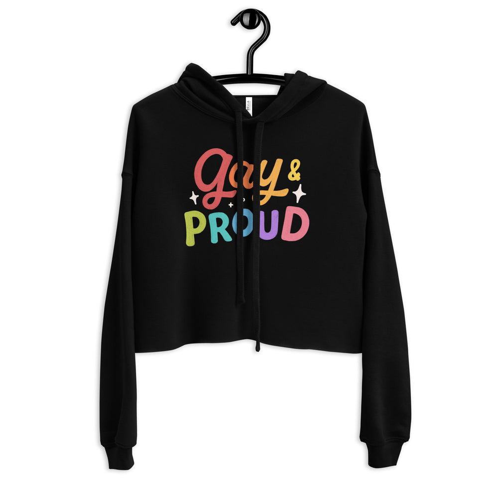 Front view of a black cropped hoodie on a hanger with colorful “Gay & Proud” lettering