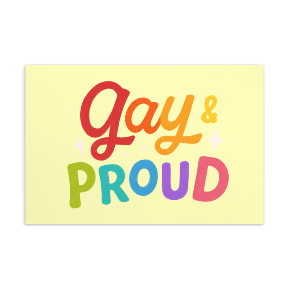 Front of a pale yellow postcard reading “Gay & Proud” in rainbow-colored lettering with sparkles