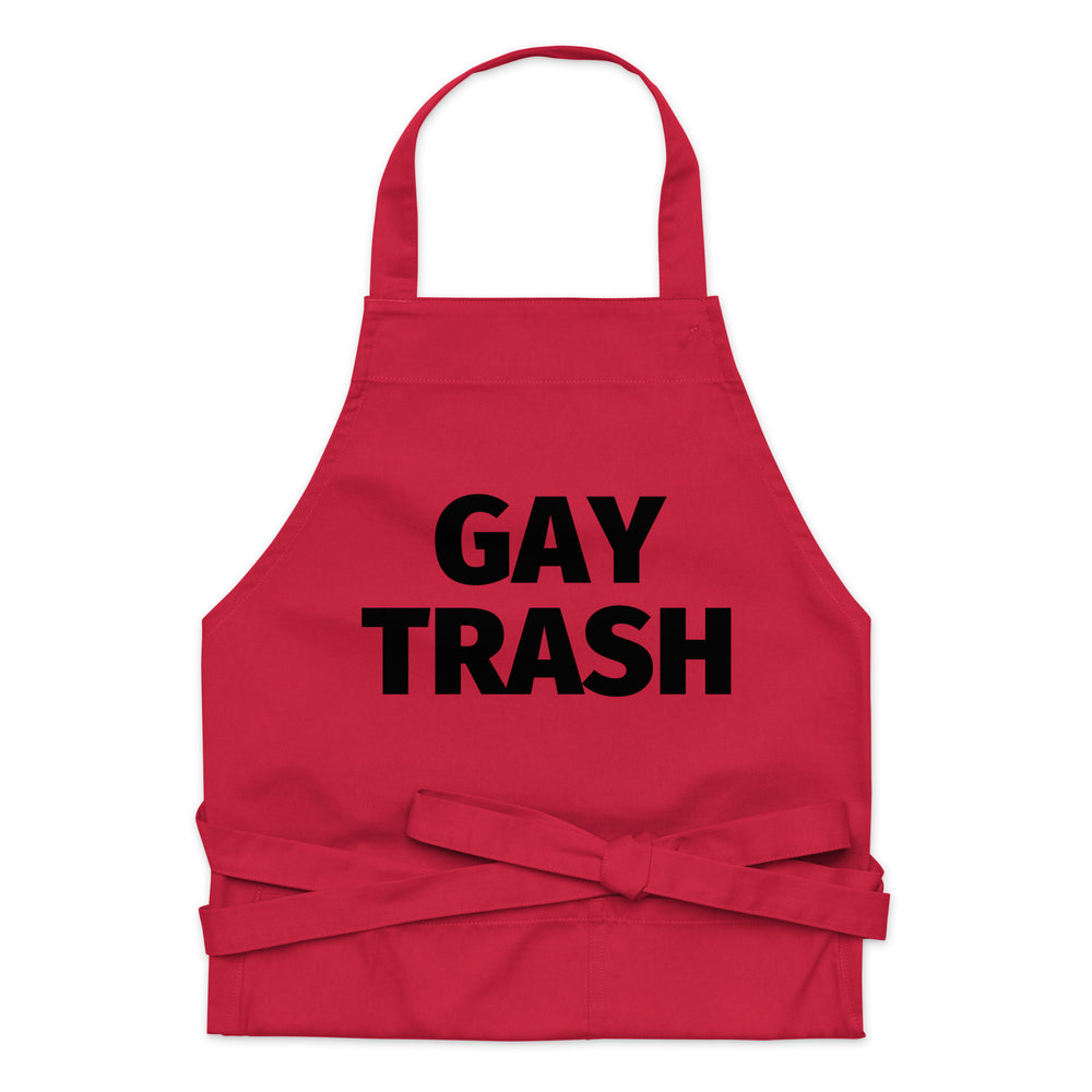Front-facing red apron with black “GAY TRASH” text, neck loop, and tied waist straps
