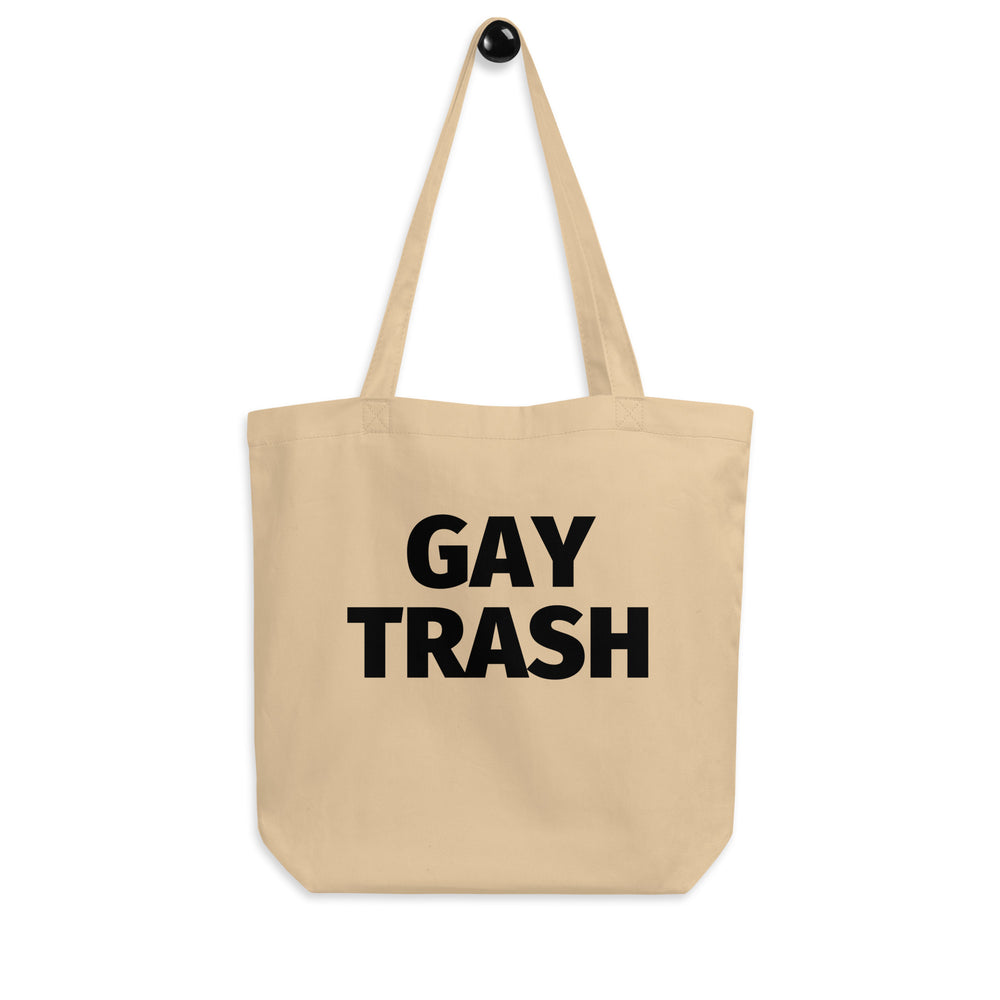 Front-facing beige tote bag with bold black text reading “GAY TRASH”