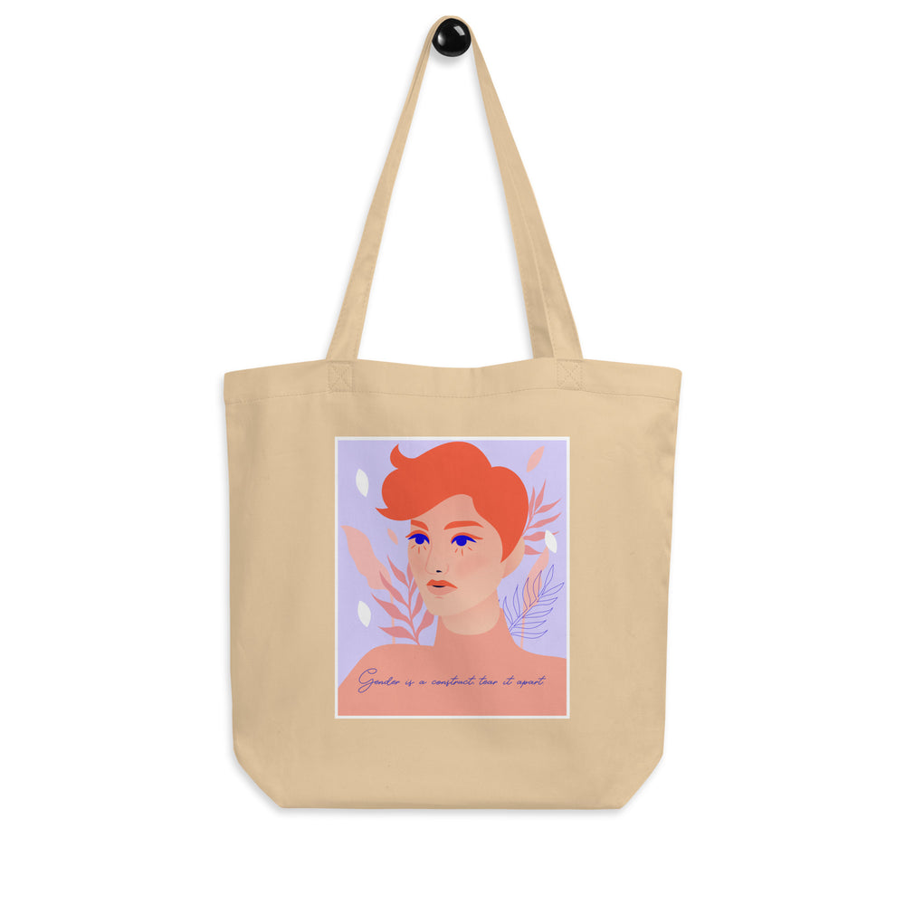 Natural canvas tote bag with a colorful portrait and “Gender is a construct tear it apart” text