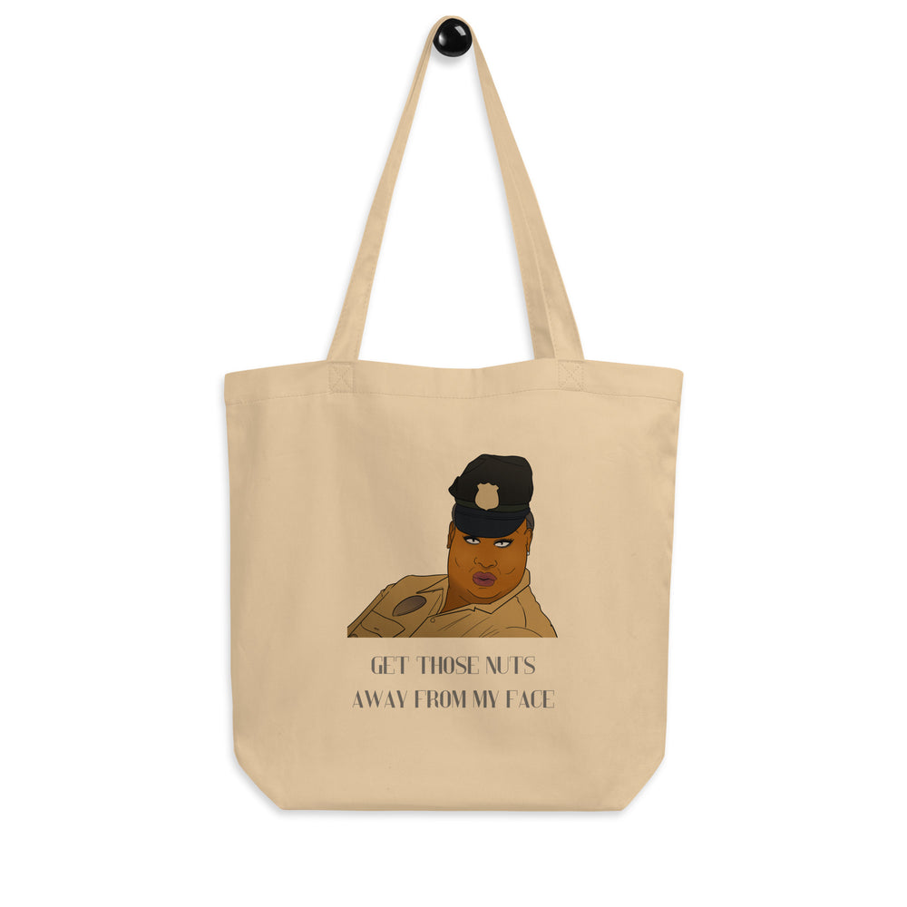 Tan tote bag with a cartoon uniformed person and the text “GET THOSE NUTS AWAY FROM MY FACE”