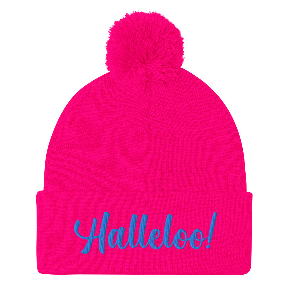 Bright pink pom-pom beanie with blue embroidered “Halleloo!” text