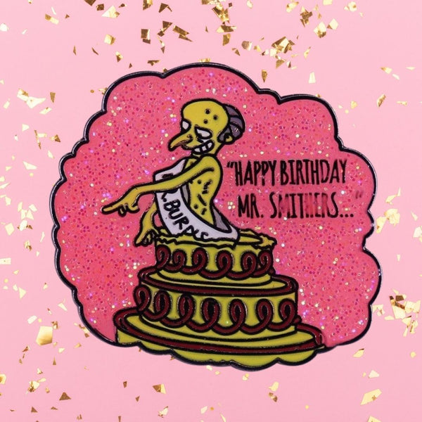 Glittery pink enamel pin showing Mr. Smithers atop a birthday cake with “Happy Birthday, Mr. Smithers…” text