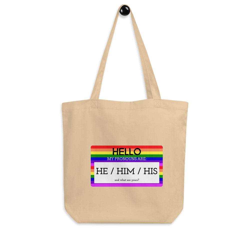 Front view of a natural canvas tote with a rainbow-bordered “HE / HIM / HIS” pronoun graphic