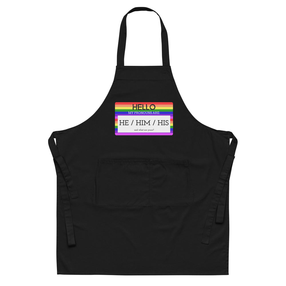 Front view of a black apron with a rainbow-bordered “Hello” pronoun patch reading “He / Him / His.”