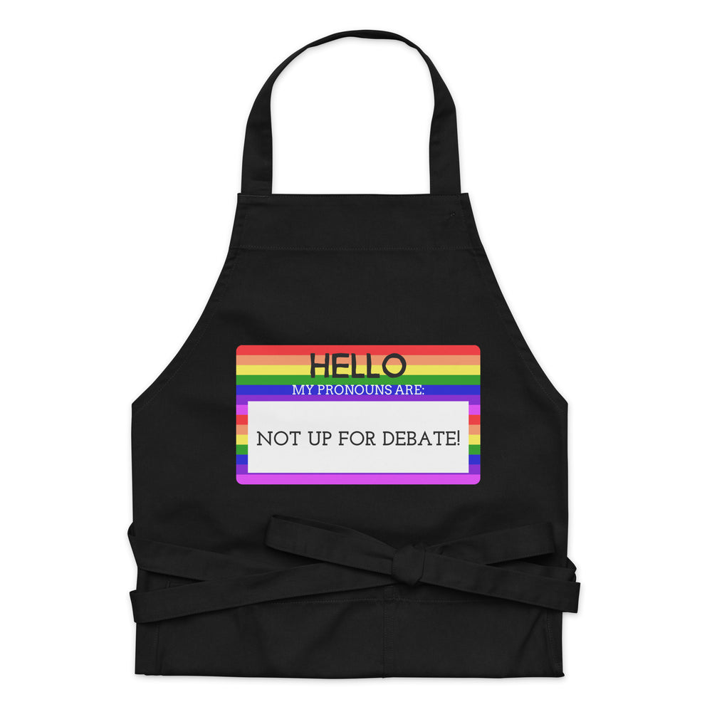 Front-facing black apron with rainbow stripes and the message “HELLO MY PRONOUNS ARE: NOT UP FOR DEBATE!”