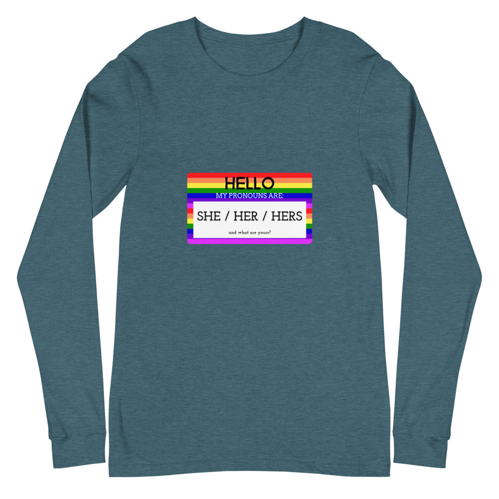 Flat-lay teal long-sleeve shirt with a rainbow-bordered pronoun card reading “SHE / HER / HERS”