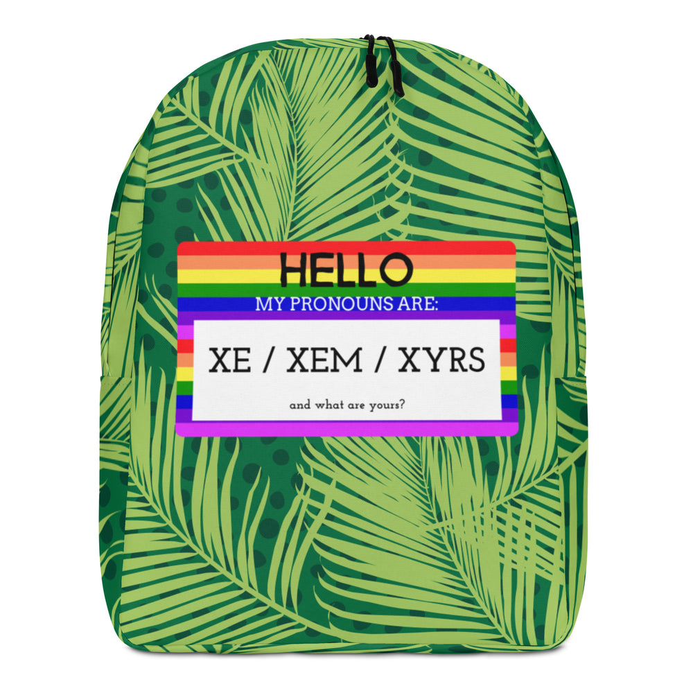 Front-facing green palm-leaf backpack with rainbow panel reading “HELLO MY PRONOUNS ARE: XE / XEM / XYRS”
