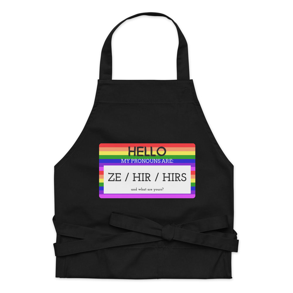 Black apron with rainbow stripes and text, “HELLO MY PRONOUNS ARE: ZE / HIR / HIRS”