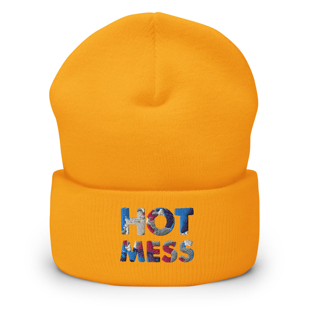Front view of an orange cuffed beanie embroidered with “HOT MESS” in multicolored thread.