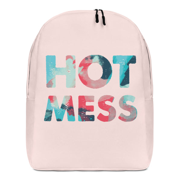 Front view of a pale pink backpack with large multicolored “HOT MESS” lettering
