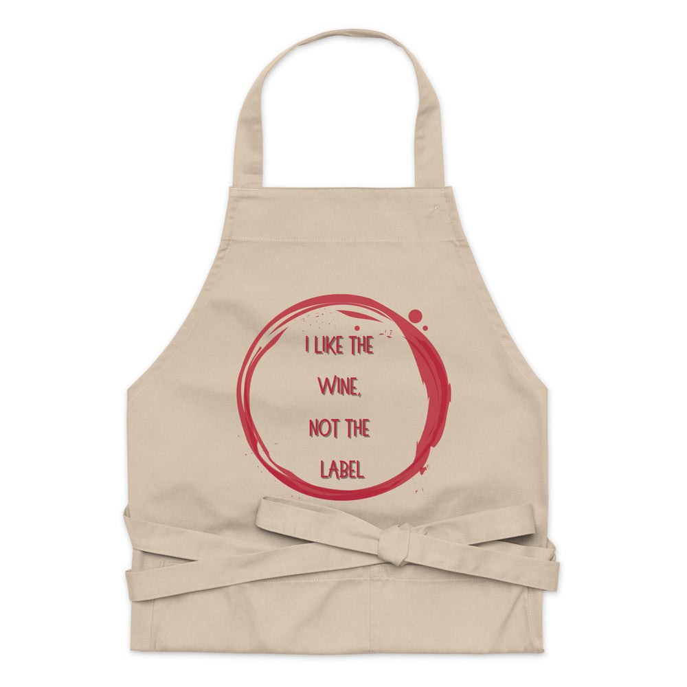 Front-facing beige apron with red wine-ring graphic and the words “I LIKE THE WINE, NOT THE LABEL”