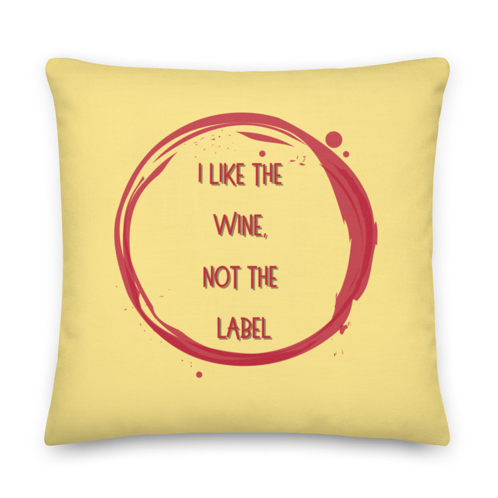 Yellow square pillow with a red wine-ring design and the words “I LIKE THE WINE, NOT THE LABEL.”