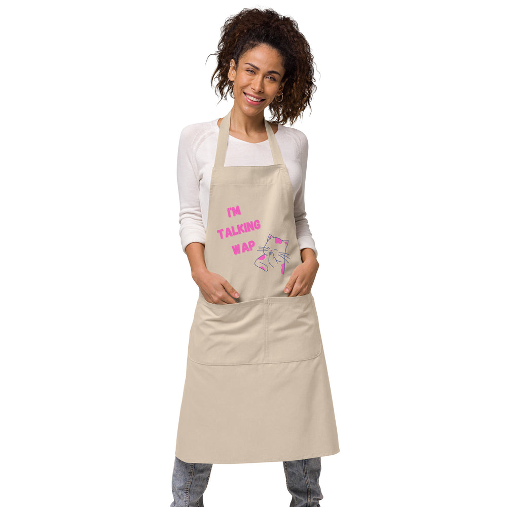 Front view of a beige apron reading “I’M TALKING WAP” with a pink cat graphic