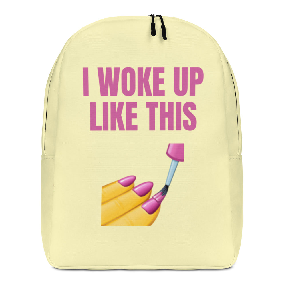 Front view of a pale yellow backpack reading “I WOKE UP LIKE THIS,” with makeup graphics
