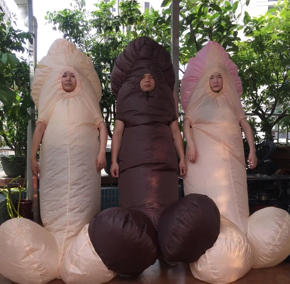 Three people wear oversized inflatable penis costumes in pink, cream, and brown