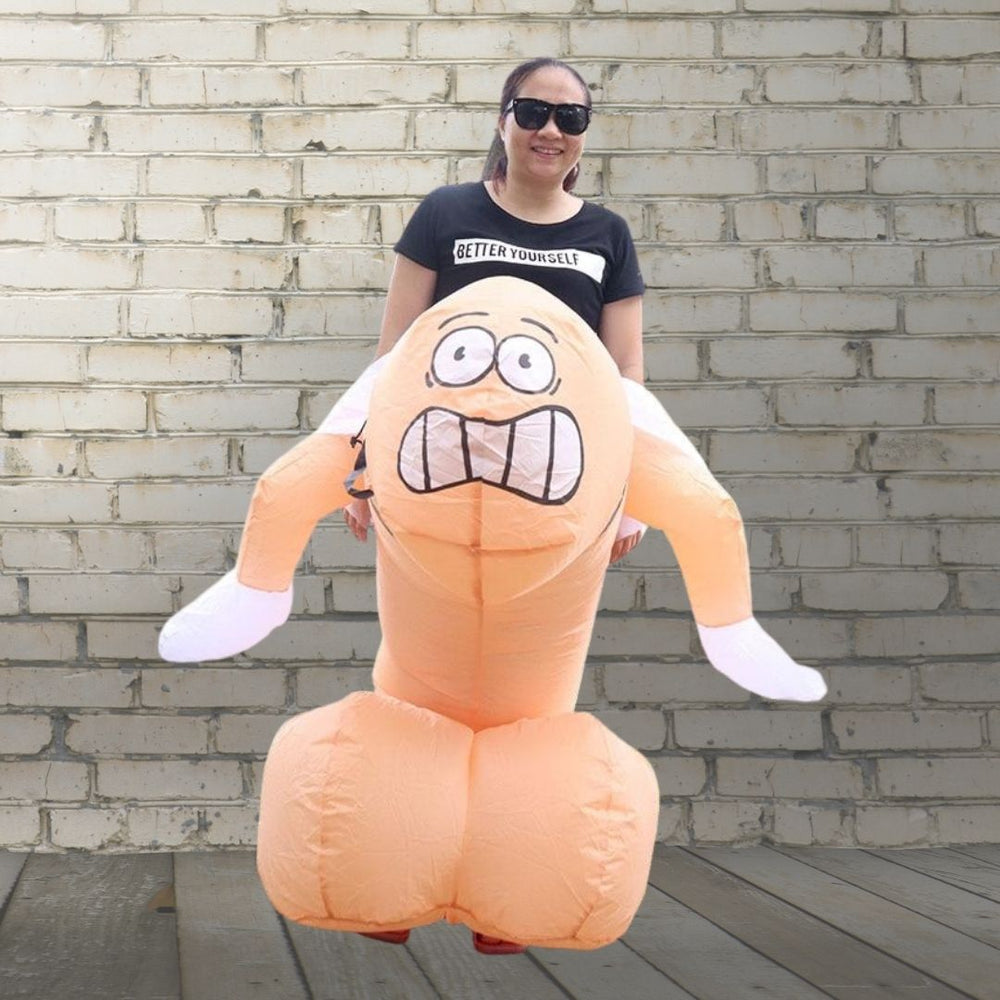 Inflatable penis costume with an angry cartoon face, worn by a person outdoors