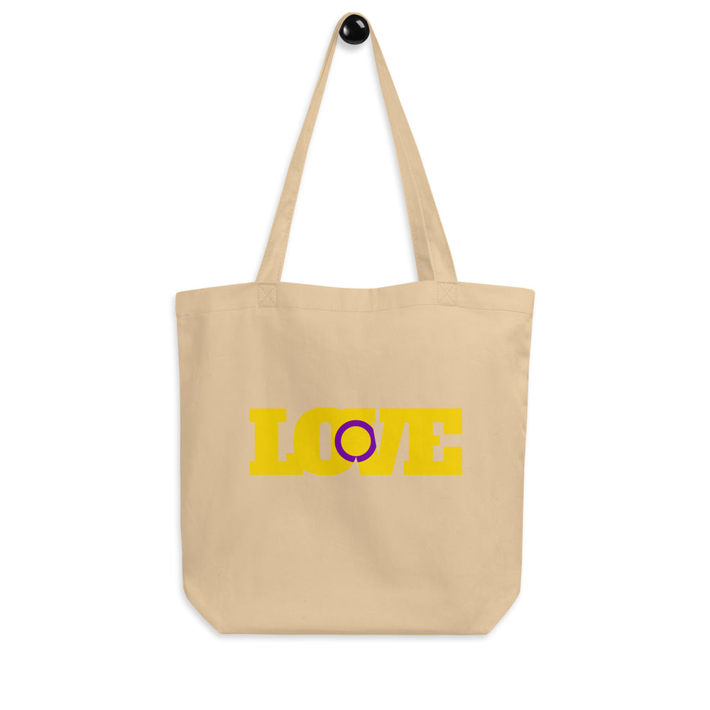Front view of a beige tote bag with yellow and purple “LOVE” lettering and long handles