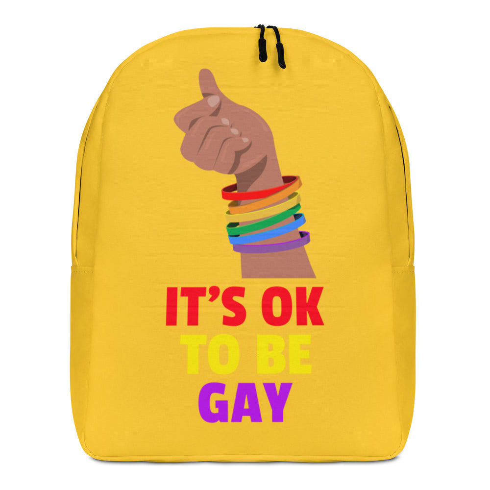 Front view of a yellow backpack reading “IT’S OK TO BE GAY,” with a raised fist in rainbow bracelets