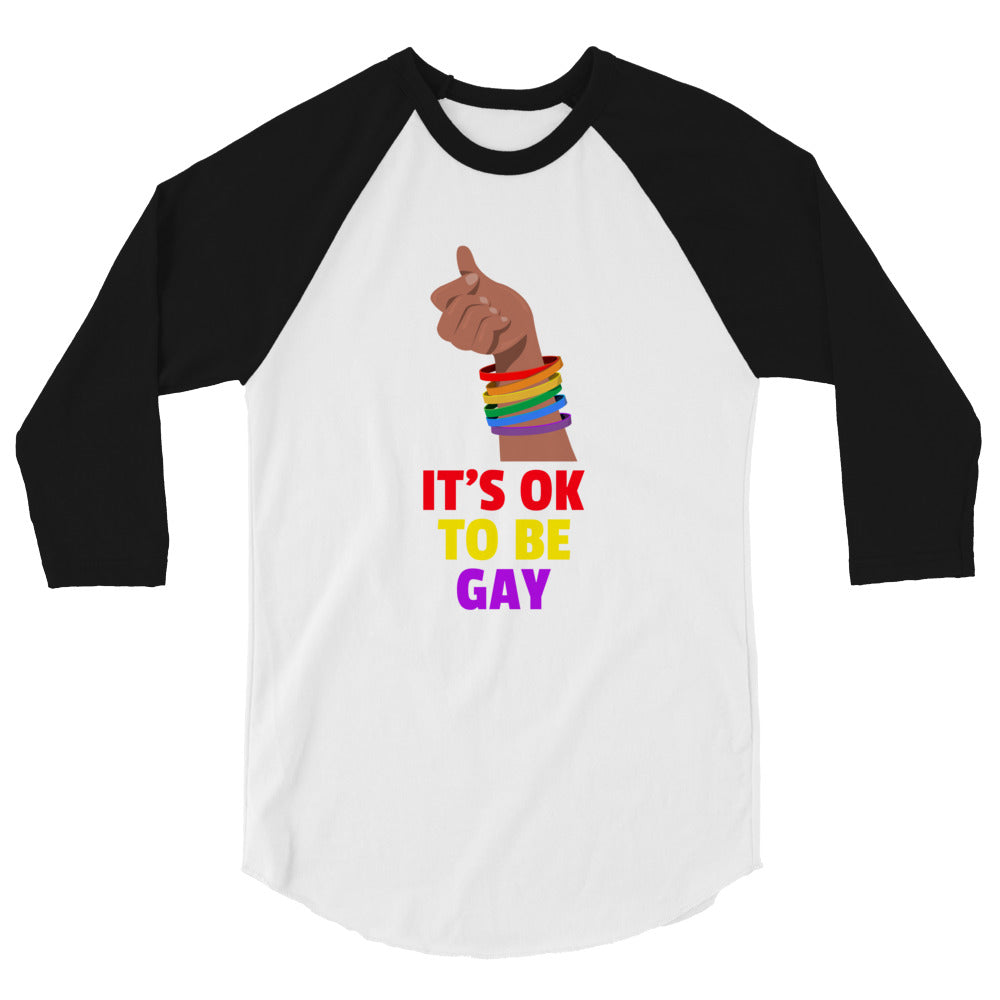 Front view of a white raglan shirt with black sleeves, rainbow bracelets, and “IT’S OK TO BE GAY” text