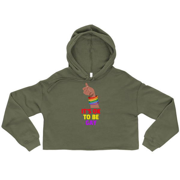 Front view of an olive cropped hoodie with rainbow bracelets and “IT’S OK TO BE GAY” text