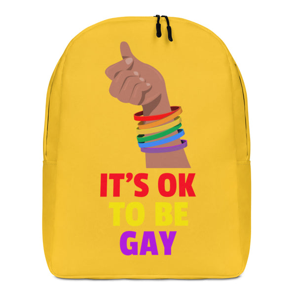 Front view of a yellow backpack reading “IT’S OK TO BE GAY,” with a raised fist in rainbow bracelets
