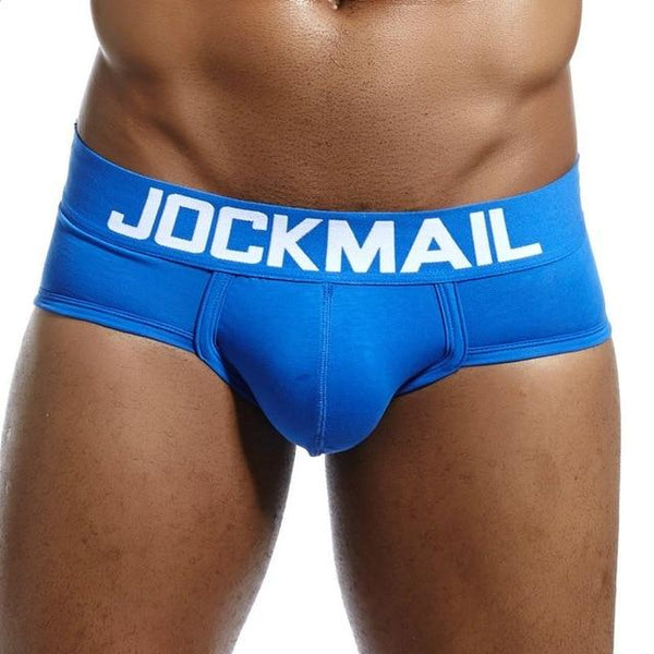 Front close-up of a model wearing bright blue low-rise briefs with a white JOCKMAIL waistband