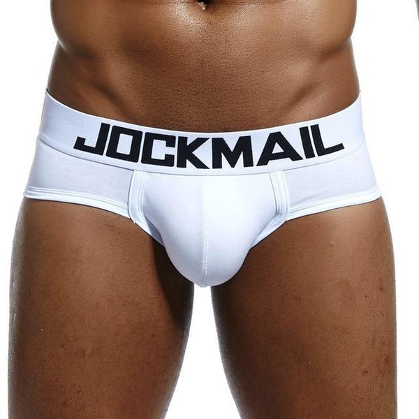 Front view of a model wearing white low-rise briefs with a black JOCKMAIL waistband
