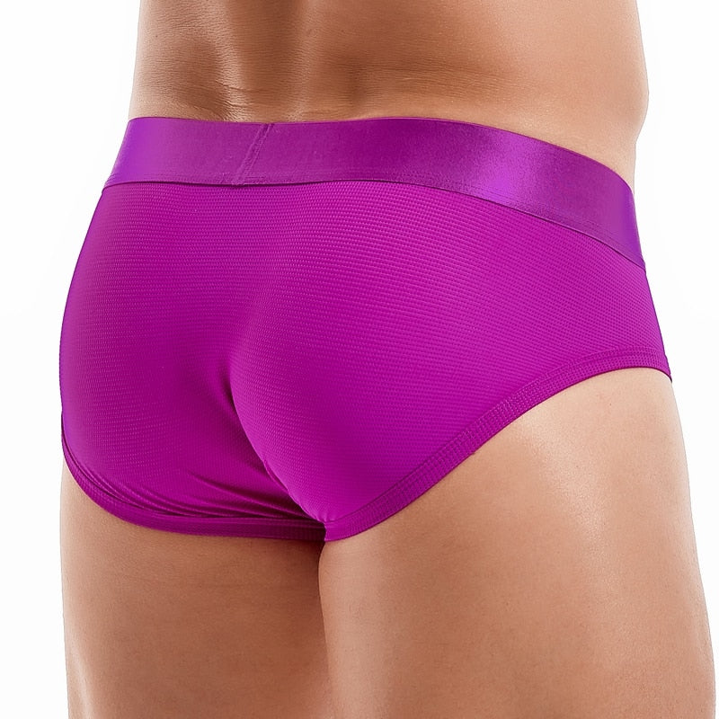 Close-up front view of a model wearing bright magenta textured briefs
