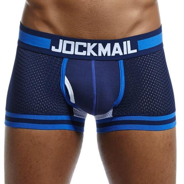 Model wearing navy mesh boxers with blue trim, white Jockmail waistband, and front pouch