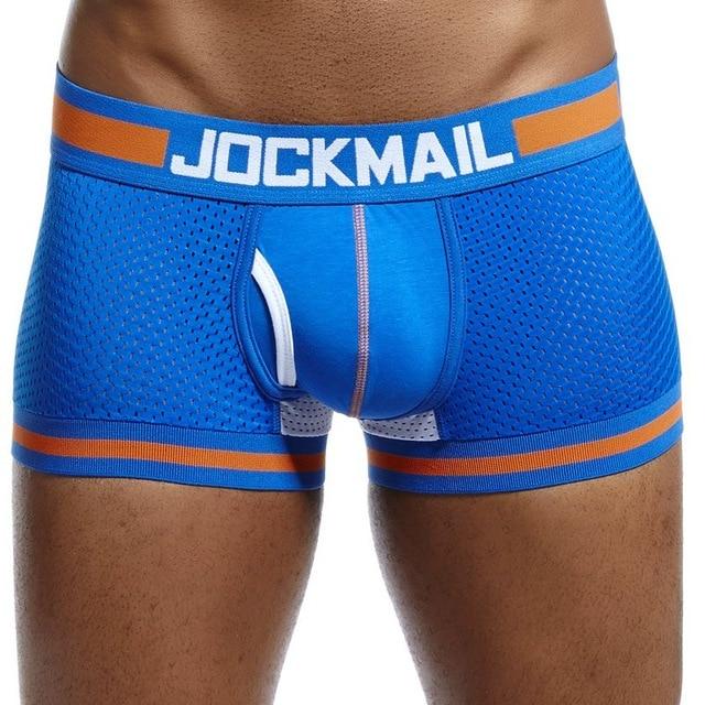 gays en boxers: Muscular person in bold blue Jockmail Mesh Boxers with orange trim, hands behind back, head cropped