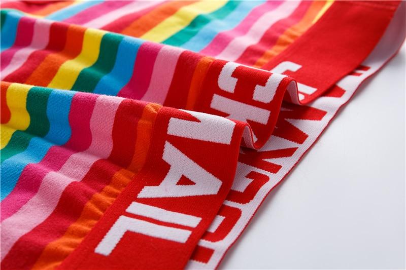 Close-up of brightly striped briefs with red elastic waistband featuring large white lettering