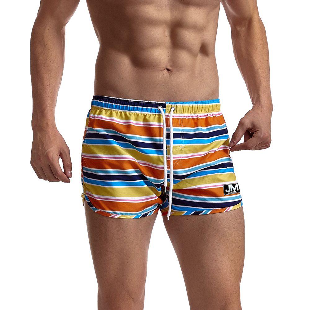 Striped multicolor board shorts with drawstring, shown worn from the front