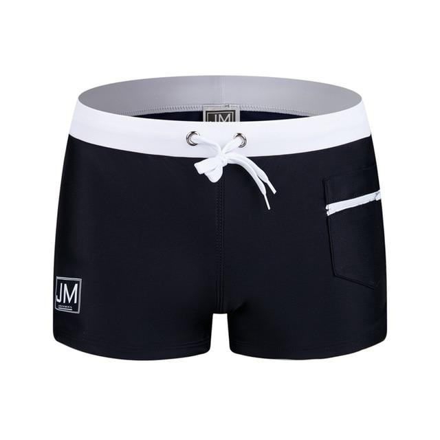 Black swim trunks with a white waistband, drawstring, and zippered side pocket