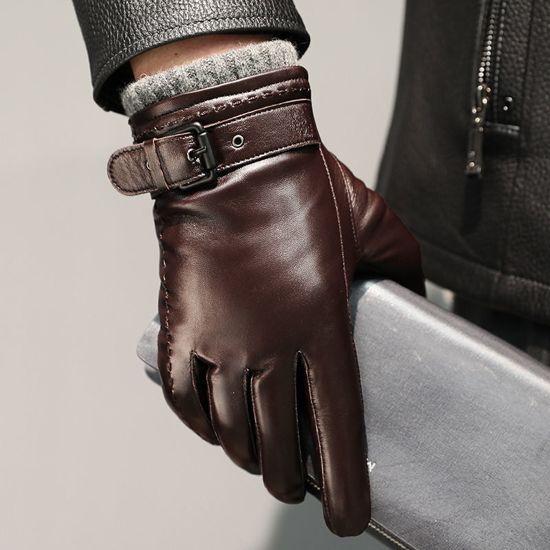 Close-up of a brown leather glove with a buckled wrist strap on a seated hand