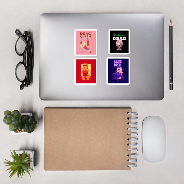 Four colorful drag-themed stickers arranged on a silver laptop