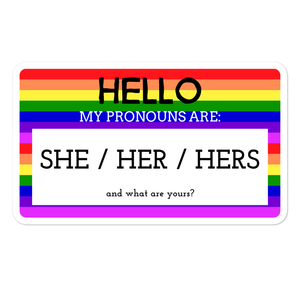 Rainbow-striped sticker reading “HELLO MY PRONOUNS ARE: SHE / HER / HERS”
