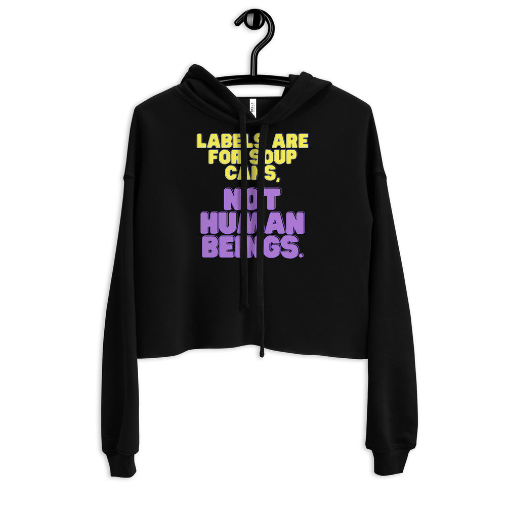 Front view of a black cropped hoodie with yellow and purple “Labels are for soup cans, not human beings.” text