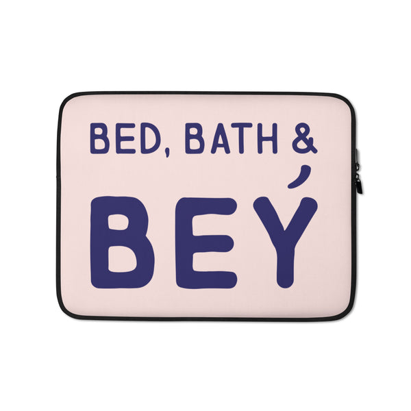 Front view of a pale pink laptop sleeve reading “BED, BATH & BEY” in dark blue