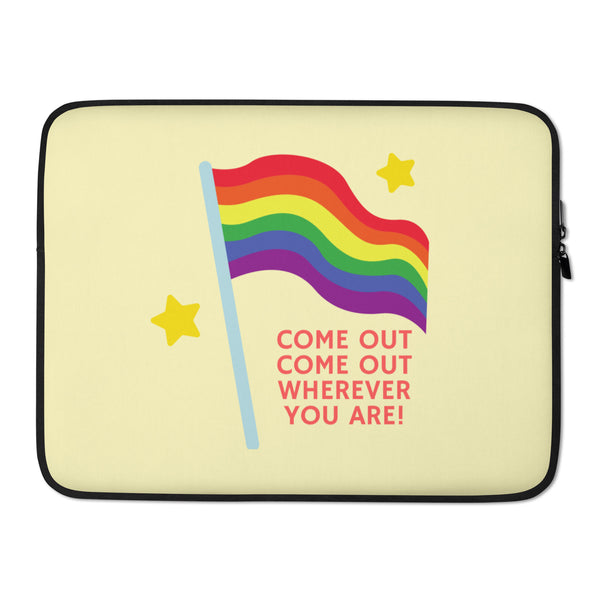 Front view of a pale yellow laptop sleeve with a rainbow flag and “COME OUT COME OUT WHEREVER YOU ARE!”