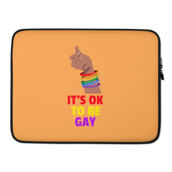 Orange laptop sleeve with a raised fist, rainbow wristbands, and “IT’S OK TO BE GAY” text