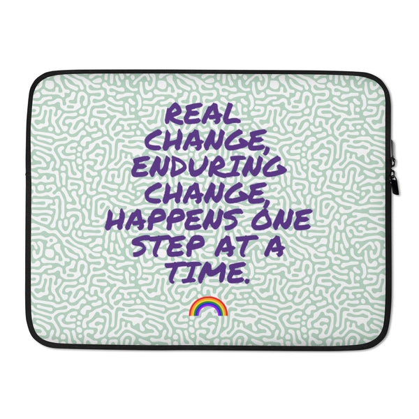 Laptop sleeve with purple “REAL CHANGE, ENDURING CHANGE, HAPPENS ONE STEP AT A TIME” lettering