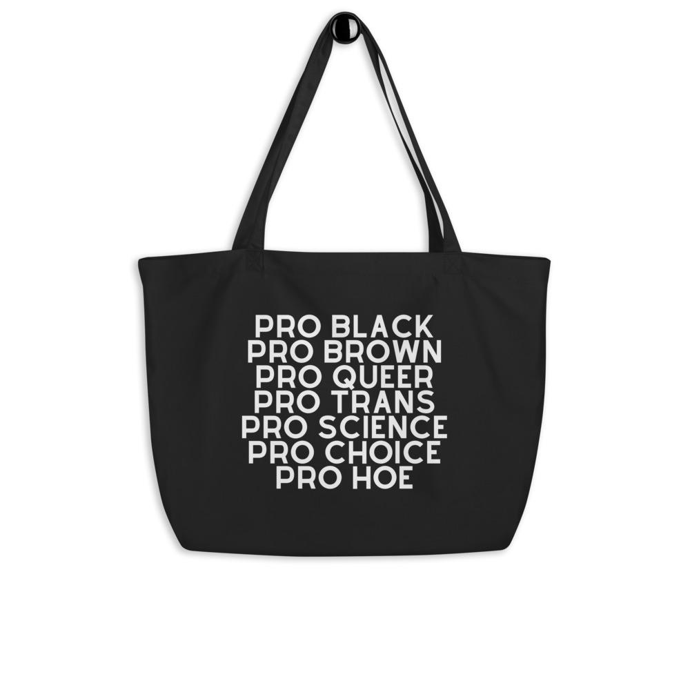 Black organic tote bag with white text reading “PRO BLACK PRO BROWN PRO QUEER PRO TRANS PRO SCIENCE PRO CHOICE PRO HOE”