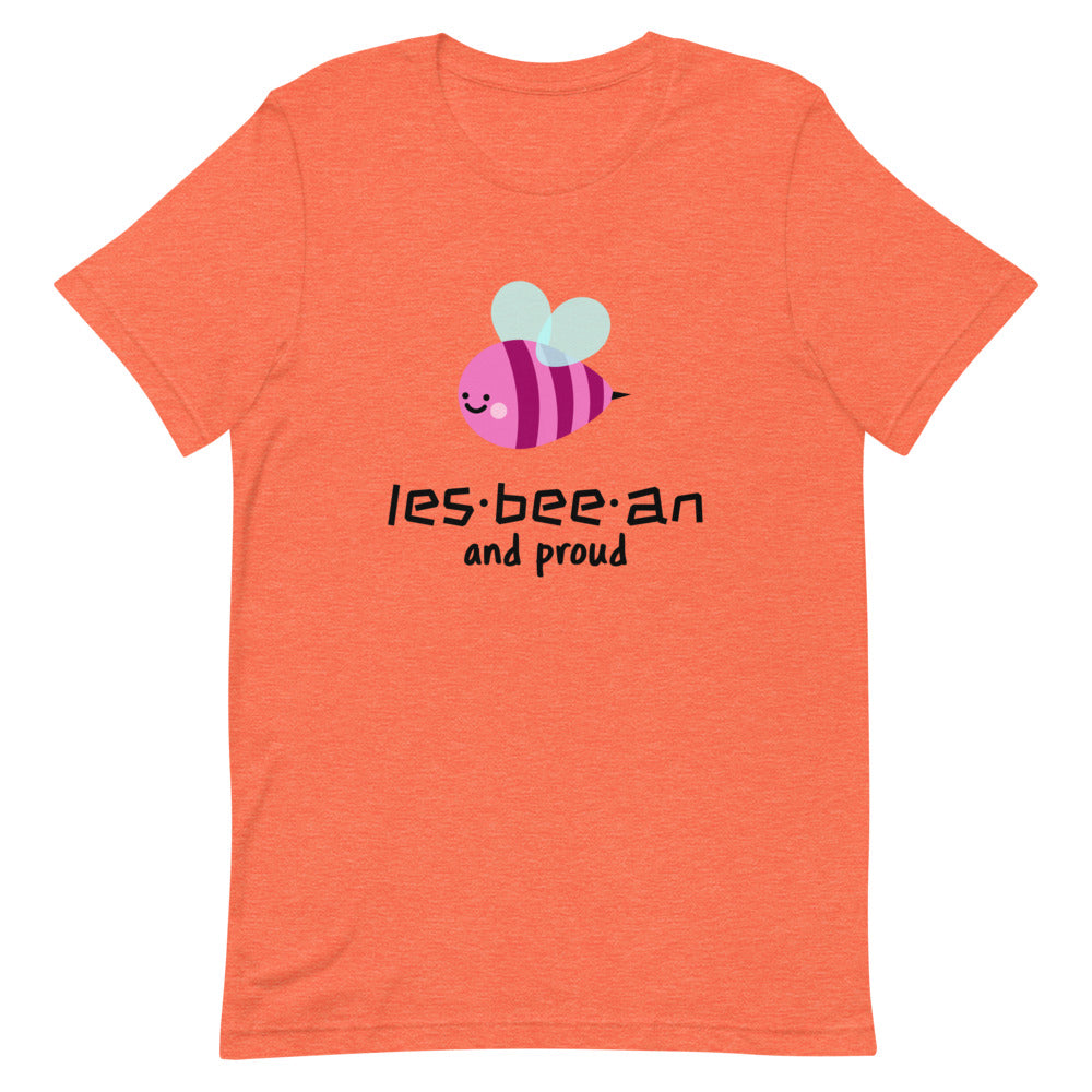 Flat-lay coral T-shirt with a smiling bee and “les-bee-an and proud” text
