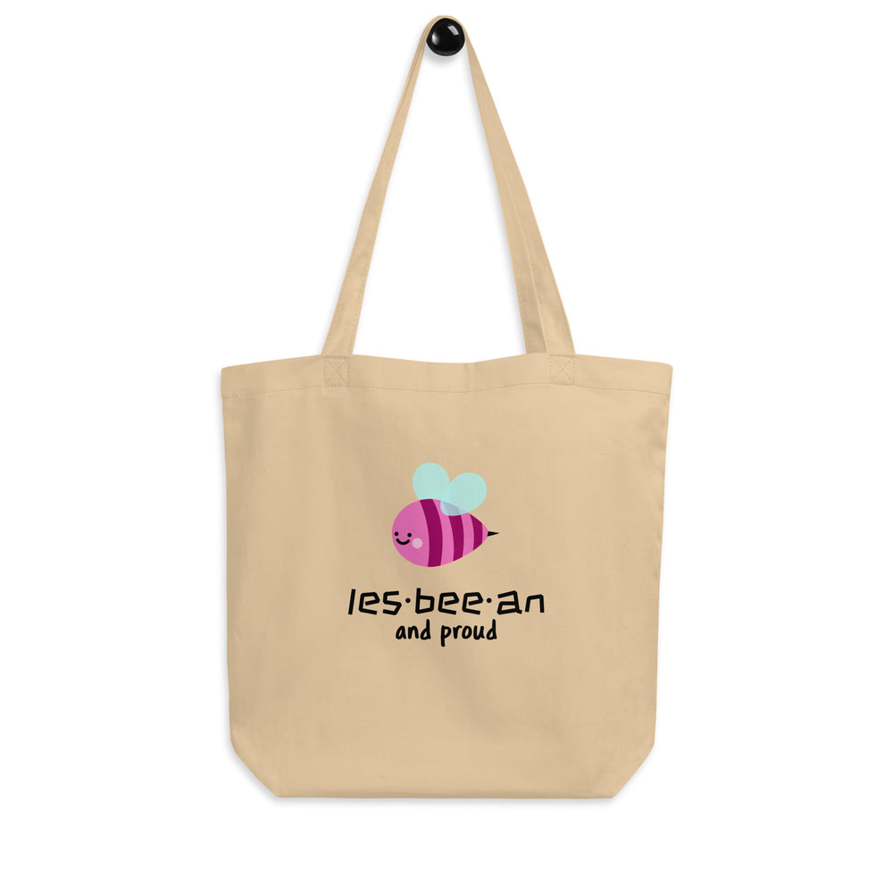 Front view of a beige tote bag with a cartoon bee and “les-bee-an and proud” text
